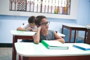 menino com TDAH distraído na escola